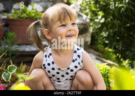 Kleine Mädchen spielen im Garten Stockfoto