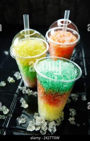 Drei bunte Slush Drinks auf schwarzem Hintergrund Stockfoto