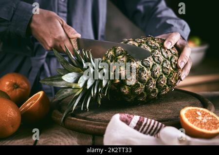 Weibchen ernten und Blätter von der Ananas abschneiden Stockfoto