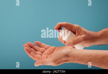 Crop man desinfiziert Hände mit Desinfektionsmittel Stockfoto