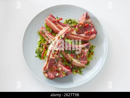 Rohe Lammkoteletts auf dem Teller Stockfoto