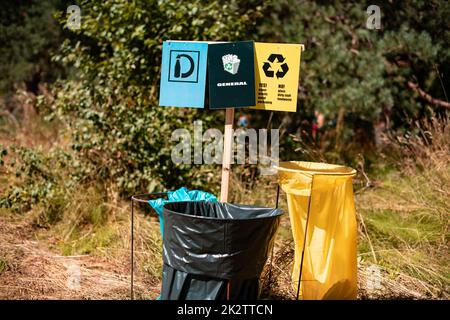 Die Müllsäcke im Wald mit Sortierschildern. Stockfoto