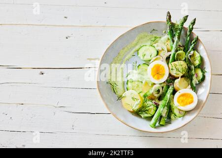 Frühlingssalat mit Spargel und Eiern auf dem Teller Stockfoto