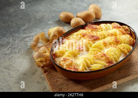 Köstliches Gratin mit Kartoffeln und knuspriger Kruste in der Pfanne Stockfoto