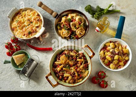 Verschiedene italienische Gerichte werden auf einem Betontisch serviert Stockfoto