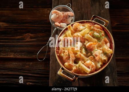 Hausgemachte Pasta mit Garnelen und Sauce, serviert auf einem Holztisch Stockfoto