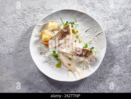 Köstliches Fischfilet mit Sauce und gebratener Kartoffel Stockfoto