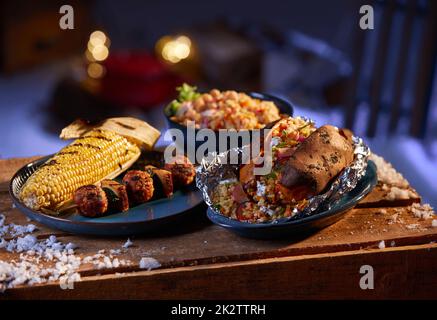 Köstliches Grillessen auf einem Holztisch im Garten Stockfoto