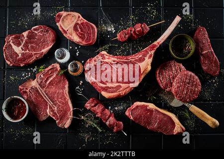 Rohe Rindersteaks, Schnitzel und Schaschlik mit Gewürzen Stockfoto