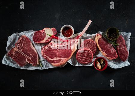 Rohe Rindersteaks und Koteletts mit Chili-Pfeffer und Gewürzen Stockfoto