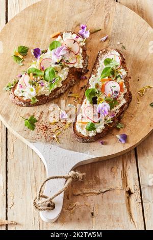 Leckere Frühlings-Bruschettas auf dem Schneidebrett Stockfoto