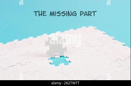 Weißes Puzzle auf blauem Hintergrund, das fehlende Teil steht auf dem Papier, arbeitet als Team zusammen, sucht nach Lösungen, das letzte Stück Stockfoto