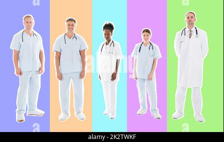 Volle Länge Portrait von zuversichtlich multiethnischen medizinisches Team stehen in der Zeile vor weißem Hintergrund Stockfoto