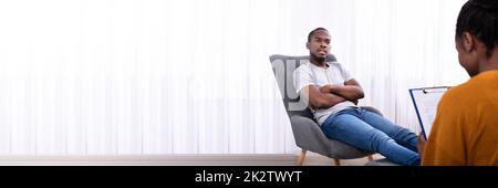 Ein Mann Sitzt Auf Dem Stuhl Neben Einem Psychologen Stockfoto