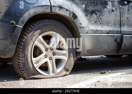 Hat während des Krieges in der Ukraine ein Auto erschossen. Ein Auto voller Zivilisten mit Splitterlöchern von Explosionen. Autounfall. Autofriedhof. Spuren von Schüssen am Körper. Das Fahrzeug wurde nach dem Beschuss beschädigt. Stockfoto