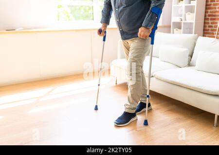 Behinderter Mann, Der Krücken Benutzt, Um Zu Gehen Stockfoto