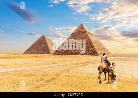 Die ägyptischen Pyramiden Chephren und Cheops und beduinen mit Touristen in der Wüste von Gizeh Stockfoto