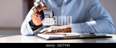 Geschäftsmann, Der Dokumente Mit Stempel Versehen Hat Stockfoto