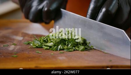 Nahaufnahme des Petersilienhackers auf einem Holzhacker Stockfoto