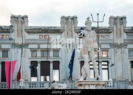 Vögel auf Neptun Statue Brunnen mit historischem Gebäude im Hintergrund Stockfoto