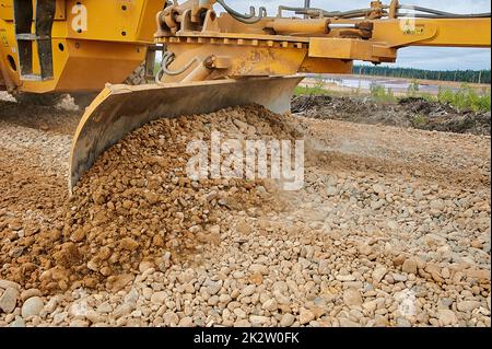 Das Grader-Blatt ebbt den Schutt auf der Baustelle Stockfoto