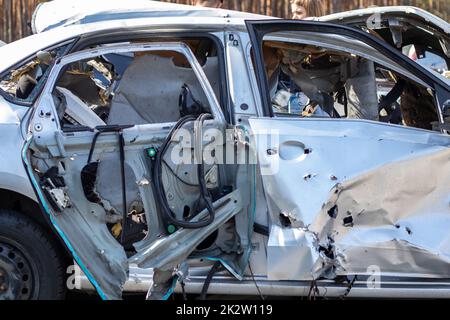 Ein verformtes, plattes Auto nach einem Unfall, nach einem starken Seitenaufprall. Autounfall, Versicherungskonzept. Furchtbar gefährliches Auto nach einem tödlichen Unfall. Leichtsinniges, gefährliches Fahren. Gefahr durch Kraftfahrzeuge. Stockfoto