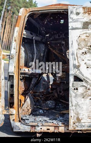 Autos nach dem Feuer. Eisenteile eines verbrannten Autos. Ausgebrannte Autos, die auf einer ruhigen Landschaft stehen. Explosion, die Folge eines Brandes. Kfz-Versicherungskonzept. Krieg Russlands gegen die Ukraine. Stockfoto