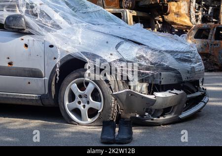 Erschossen, beschädigte Autos während des Krieges in der Ukraine. Das Fahrzeug der von den Händen des russischen Militärs betroffenen Zivilisten. Schrapnell und Einschusslöcher in der Karosserie des Autos. Krieg Russlands gegen die Ukraine. Stockfoto