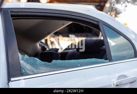 Krimineller Zwischenfall. In ein Auto einbrechen, das auf der Straße geparkt ist. Seitenscheibe und Fahrgastraum dahinter gebrochen. Ein Verbrechen, das von einem Dieb begangen wurde, Dinge zu stehlen. Auto nach Unfall. Stockfoto