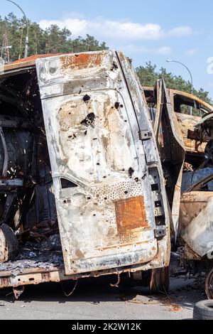 Autos nach dem Feuer. Eisenteile eines verbrannten Autos. Ausgebrannte Autos, die auf einer ruhigen Landschaft stehen. Explosion, die Folge eines Brandes. Kfz-Versicherungskonzept. Krieg Russlands gegen die Ukraine. Stockfoto