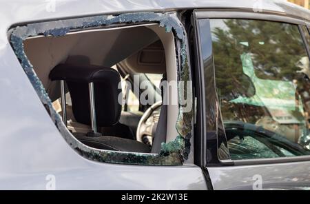 Krimineller Zwischenfall. In ein Auto einbrechen, das auf der Straße geparkt ist. Seitenscheibe und Fahrgastraum dahinter gebrochen. Ein Verbrechen, das von einem Dieb begangen wurde, Dinge zu stehlen. Auto nach Unfall. Stockfoto