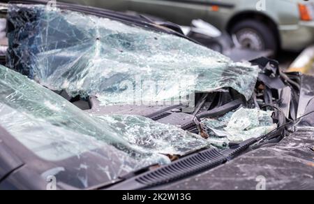 Nahaufnahme eines Autos mit gebrochener Windschutzscheibe nach einem tödlichen Unfall. Folge eines tödlichen Autounfalls. Gefahr durch Kraftfahrzeuge. Leichtsinniges, gefährliches Fahren. Fahrzeug nach einem Unfall mit einem Fußgänger. Stockfoto