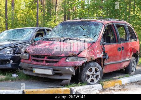 Erschossen, beschädigte Autos während des Krieges in der Ukraine. Das Fahrzeug der von den Händen des russischen Militärs betroffenen Zivilisten. Schrapnell und Einschusslöcher in der Karosserie des Autos. Krieg Russlands gegen die Ukraine. Stockfoto