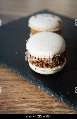 Ein köstliches Pasta-Dessert - ein süßes französisches Leckerbissen liegt auf einem schwarzen Betonstand, Nahaufnahme. Stockfoto