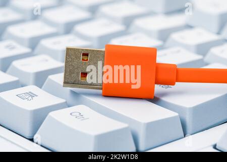 Computertastatur mit großen Tasten und orangefarbenem USB-Kabel Stockfoto