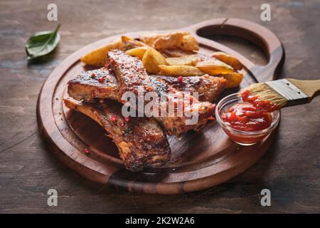 Scharfe, gegrillte Spare Ribs. Gegrillte und geräucherte Rippchen mit Barbecue-Sauce auf einem Schnitzbrett. Stockfoto