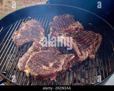 Cowboy-Steak gegrillt. Ribeye Steak auf dem Knochen auf dem Grillgitter. Stockfoto