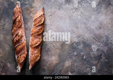Zwei frisch gebackene Baguettes auf Steinhintergrund. Stockfoto