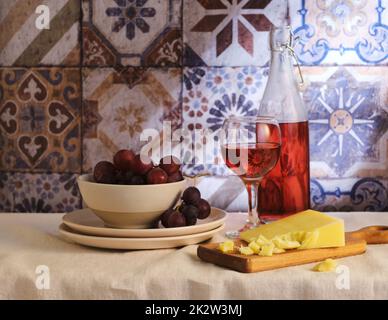 Tischset-Käse mit Wein und Obst. Mediterrane Küche Stockfoto