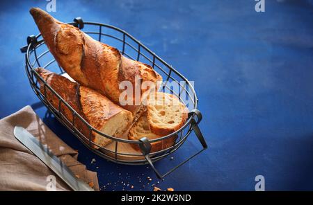 Frisch gebackenes französisches Baguette in einem wunderschönen Korb. Stockfoto