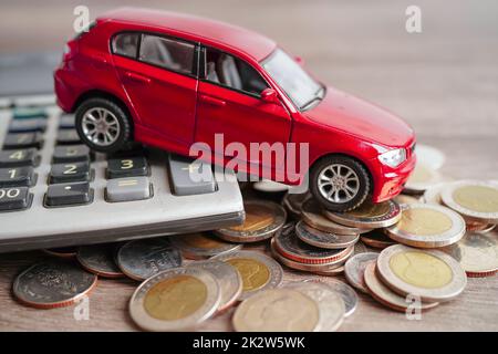 BANGKOK, THAILAND - 18. MAI 2022 Auto auf Münzen und Rechner Auto Darlehen, Finanzen, Geld sparen, Versicherung und Leasing-Zeit-Konzept. Stockfoto