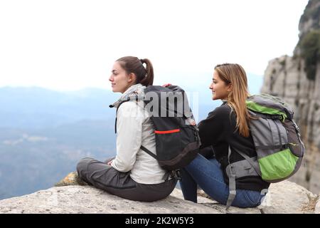 Zwei Rucksacktouristen, die über die Aussicht auf den Berg nachdenken Stockfoto