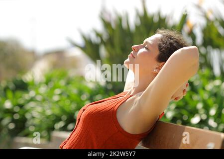 Profil einer Frau, die auf einer Bank im Park ruht Stockfoto