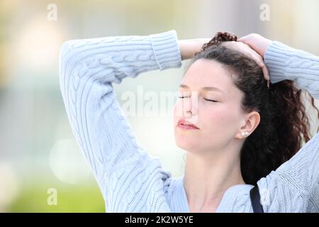 Eine Frau auf der Straße, die Pferdeschwanz macht Stockfoto