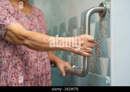 Asiatische ältere oder ältere alte Dame Frau Patienten verwenden Toilette Badezimmer Griff Sicherheit in Krankenpflege-Station, gesund starke medizinische Konzept. Stockfoto