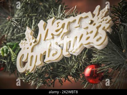 Inschrift Frohe Weihnachten auf einem Weihnachtsbaumzweig Stockfoto