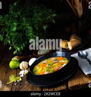 Herzhafte, rustikale Erbsensuppe mit Speck und Wurst Stockfoto