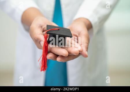 Asiatische Arzt Studie lernen mit Abschluss GAP Hut in Krankenhausstation, clever hell Genie Bildung Medizin Konzept. Stockfoto
