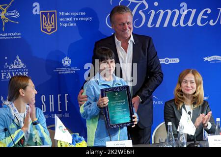 KIEW, UKRAINE - 21. SEPTEMBER 2022 - der Präsident der Ukrainischen Vereinigung für Tauchen und künstlerisches Schwimmen Ihor Lysov überreicht ein Zertifikat für ein Apart Stockfoto