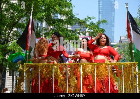 Eine Gruppe Mädchen in roten Kleidern, die in der Annual Dance Parade entlang der Fifth Avenue tanzen Stockfoto